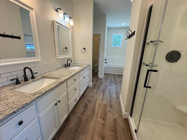 22585 State Highway K, Novinger, MO 63559 - bathroom featuring wood finished floors, double vanity, a stall shower, and tasteful backsplash