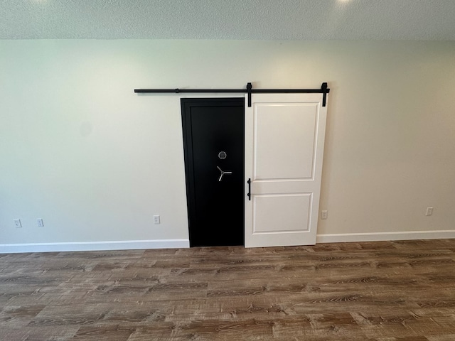 22585 State Highway K, Novinger, MO 63559 - empty room featuring wood finished floors, a barn door, and a textured ceiling
