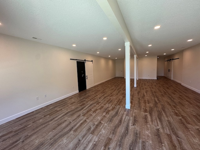 22585 State Highway K, Novinger, MO 63559 - basement with a barn door, dark wood finished floors, a textured ceiling, and recessed lighting