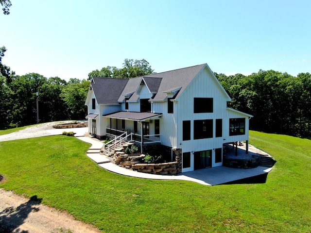 22585 State Highway K, Novinger, MO 63559 - rear view of property with board and batten siding, a lawn, dirt driveway, a patio area, and a standing seam roof