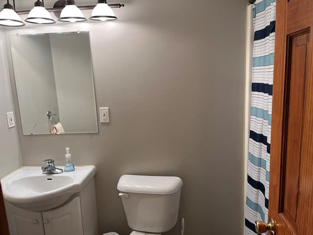 bathroom with toilet, curtained shower, and vanity