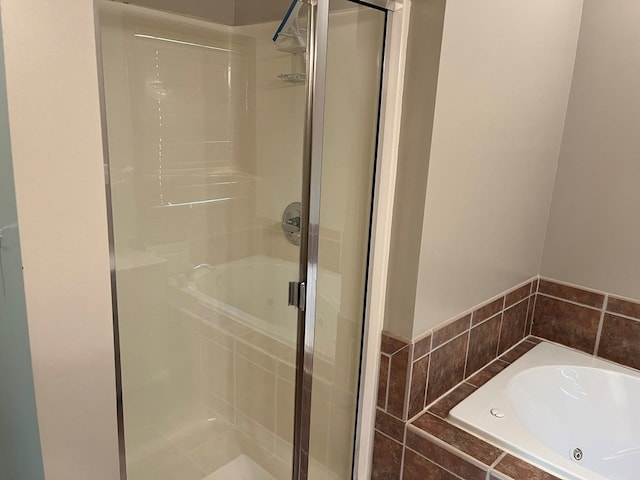 bathroom featuring a garden tub and a shower stall