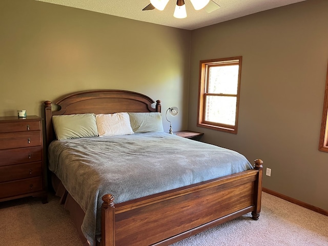 carpeted bedroom featuring baseboards and a ceiling fan