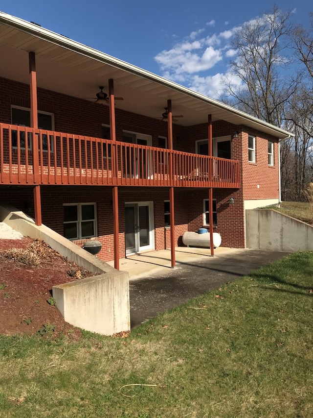 back of house with a deck, a patio area, brick siding, and ceiling fan