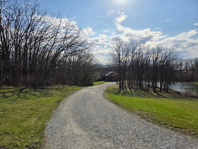 view of road featuring a water view and driveway