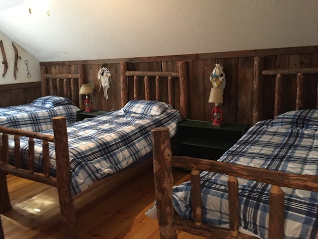 bedroom featuring hardwood / wood-style floors and lofted ceiling