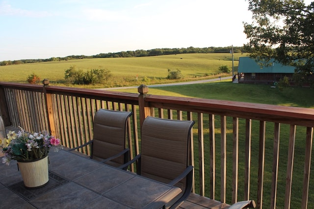 wooden deck featuring a lawn and a rural view