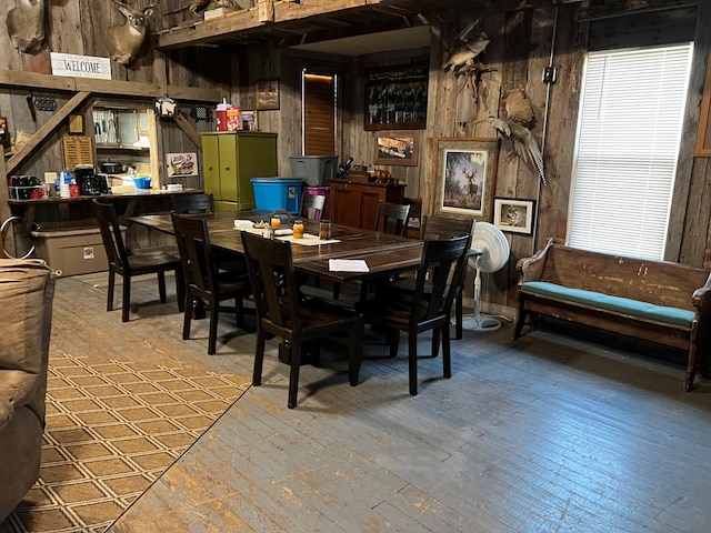 dining room featuring hardwood / wood-style flooring and wood walls