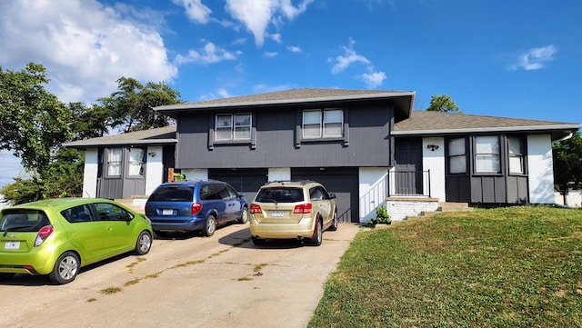 split level home featuring a garage and a front lawn