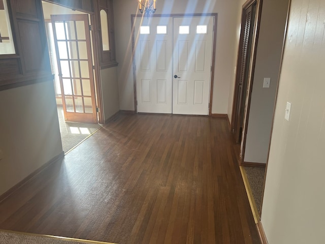 interior space with arched walkways, dark wood-style flooring, and baseboards