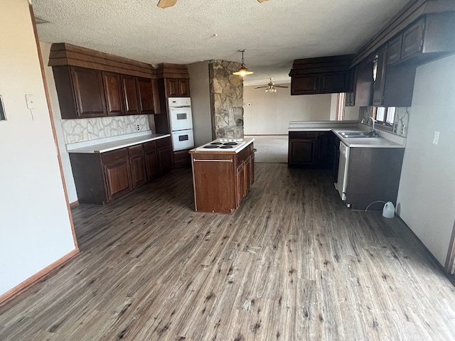 kitchen with a ceiling fan, a center island, white appliances, and wood finished floors