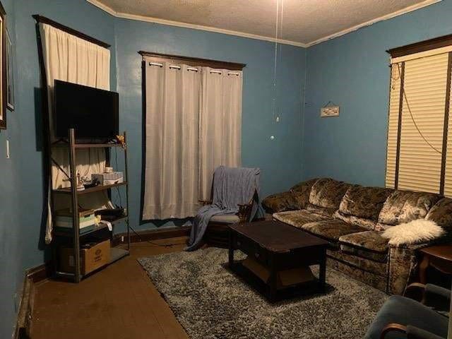 living room with crown molding and hardwood / wood-style flooring