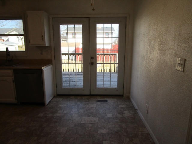 doorway to outside featuring a textured wall, a sink, visible vents, baseboards, and french doors