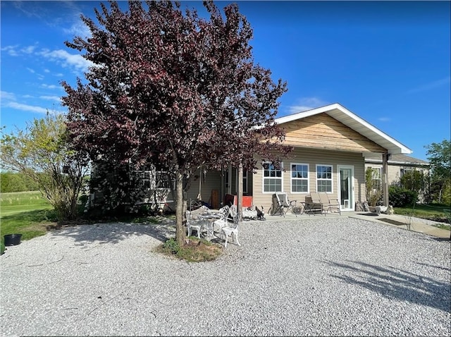 rear view of property with gravel driveway