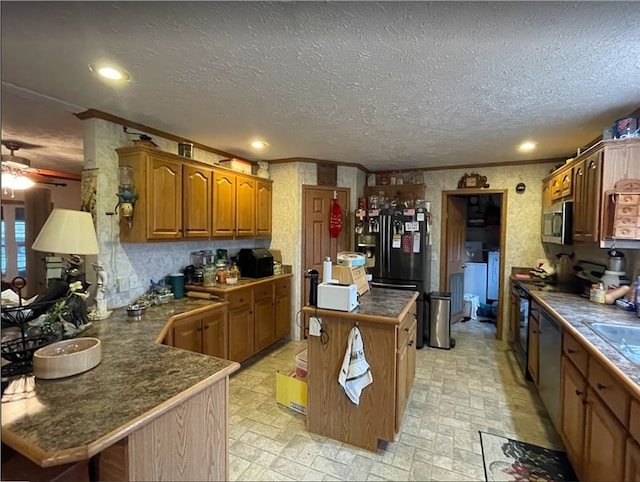 kitchen with a peninsula, a kitchen island, black appliances, brown cabinetry, and dark countertops