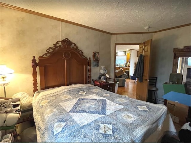 bedroom featuring a textured ceiling, ornamental molding, and wood finished floors