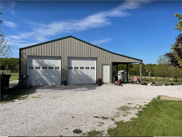 garage with driveway and a detached garage