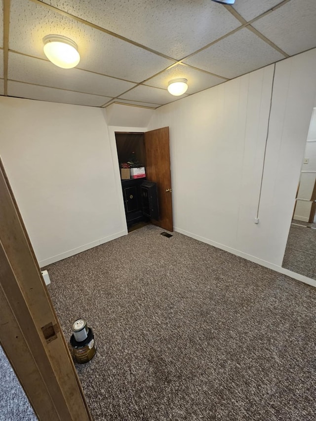 interior space featuring a drop ceiling and baseboards