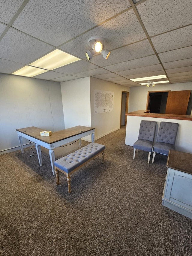 playroom with baseboards, dark colored carpet, and a drop ceiling