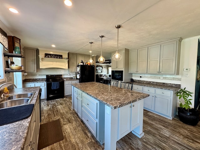 210 N Grant St, Green City, MO 63545 - kitchen with black appliances, a sink, dark wood-style flooring, decorative light fixtures, and a center island