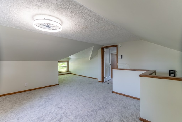 516 Barrow St, Moberly, MO 65270 - bonus room with lofted ceiling, a textured ceiling, carpet floors, and baseboards