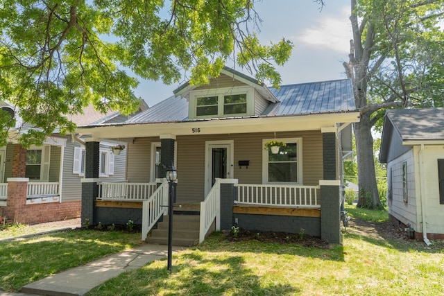516 Barrow St, Moberly, MO 65270 - bungalow featuring a porch, a front yard, and metal roof