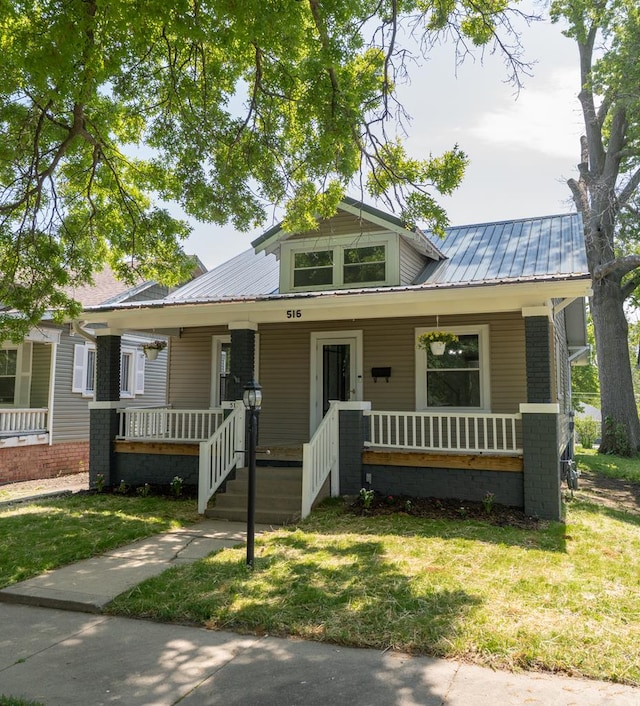 516 Barrow St, Moberly, MO 65270 - bungalow-style home with a porch, metal roof, and a front yard