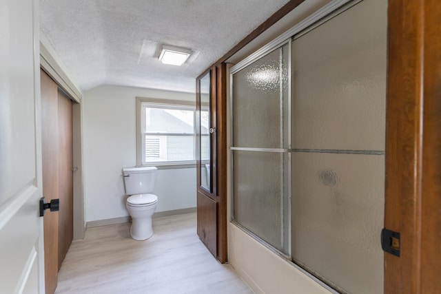 516 Barrow St, Moberly, MO 65270 - bathroom featuring toilet, lofted ceiling, wood finished floors, a textured ceiling, and enclosed tub / shower combo