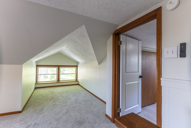 516 Barrow St, Moberly, MO 65270 - bonus room with lofted ceiling, a textured ceiling, baseboards, and carpet flooring