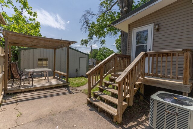 516 Barrow St, Moberly, MO 65270 - wooden deck with cooling unit, an outbuilding, and a patio