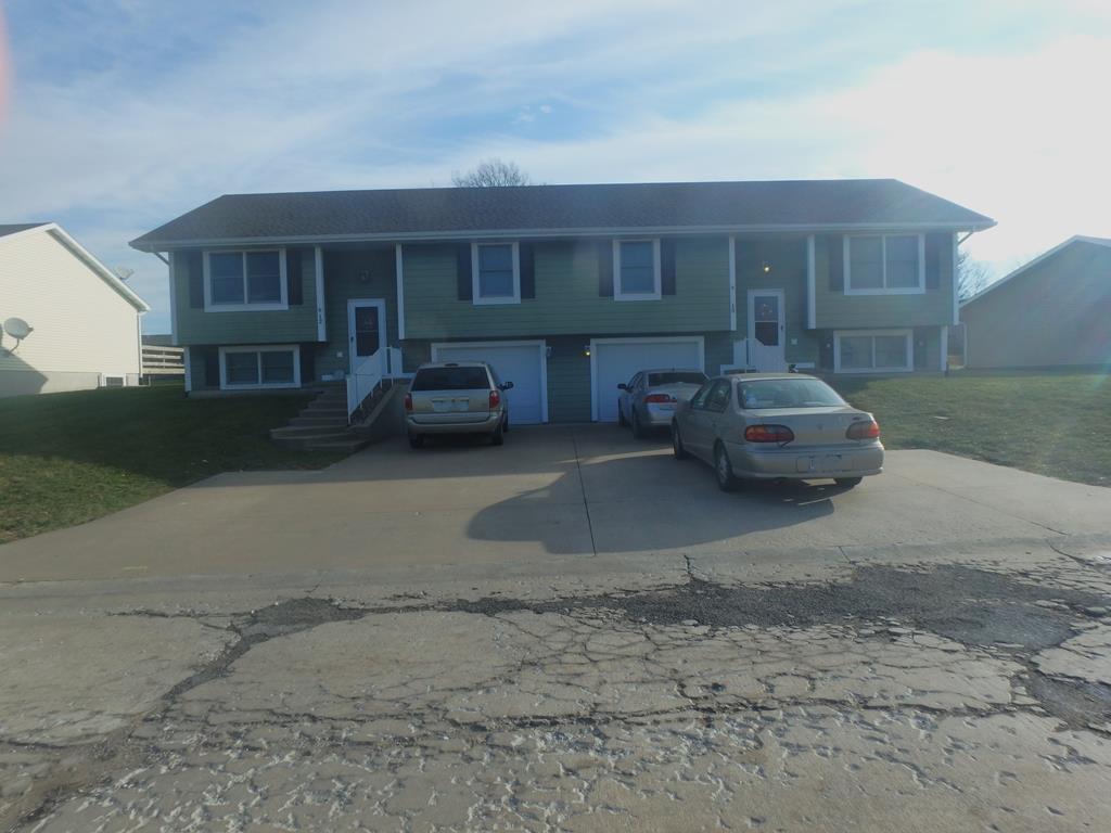 raised ranch with driveway and an attached garage