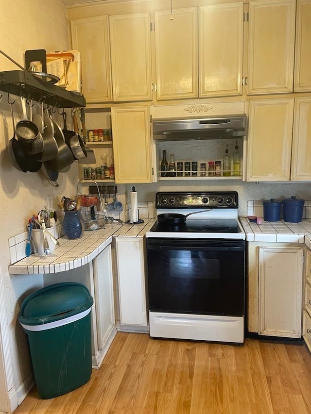 411 W W, Callao, MO 63534 - kitchen with electric stove, tile countertops, under cabinet range hood, and light wood-style flooring
