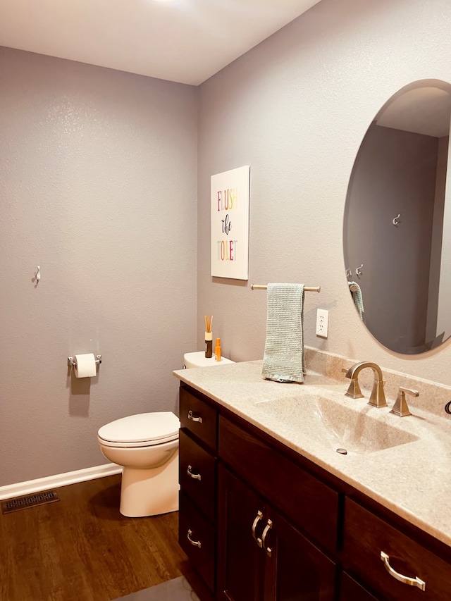 bathroom with vanity, wood-type flooring, and toilet