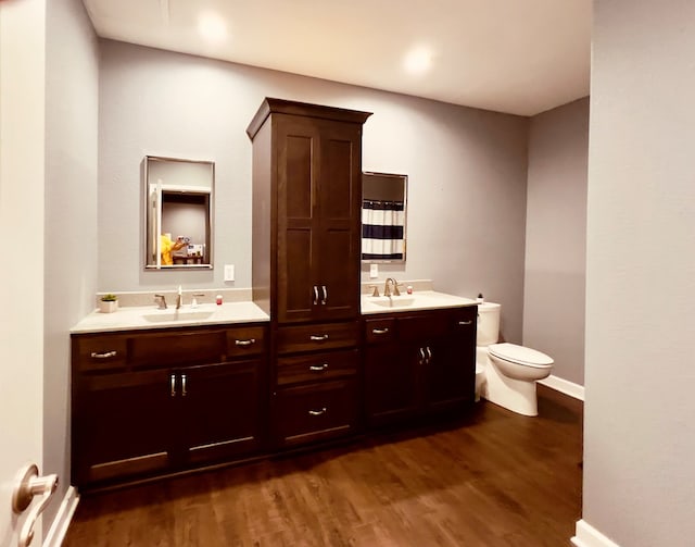 bathroom with hardwood / wood-style flooring, vanity, and toilet