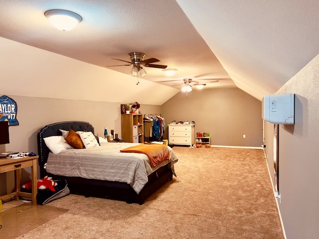 carpeted bedroom featuring ceiling fan, vaulted ceiling, and a textured ceiling