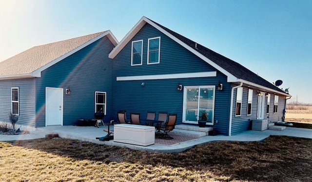 back of property with a lawn and a patio area