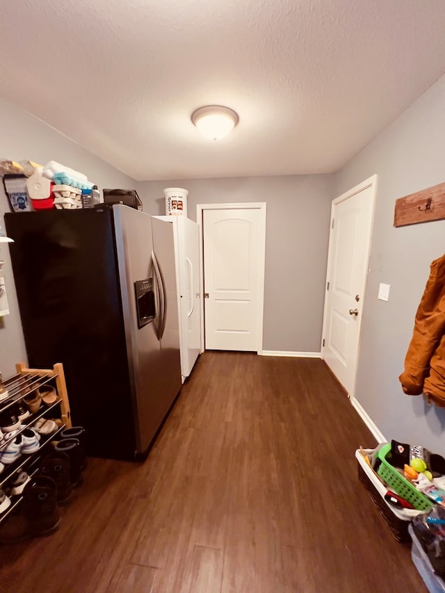 clothes washing area featuring dark wood-type flooring and a textured ceiling