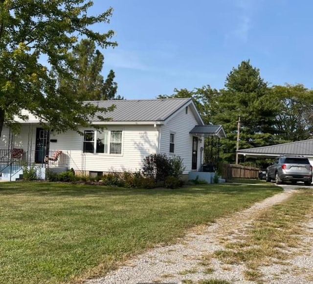 view of front of property featuring a front lawn and a carport