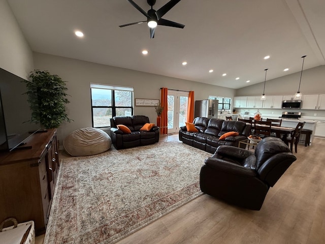 living room featuring ceiling fan, light hardwood / wood-style flooring, lofted ceiling, and french doors