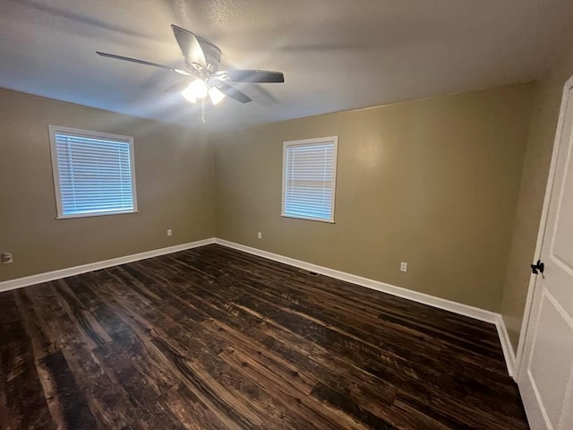 spare room with dark hardwood / wood-style flooring and ceiling fan