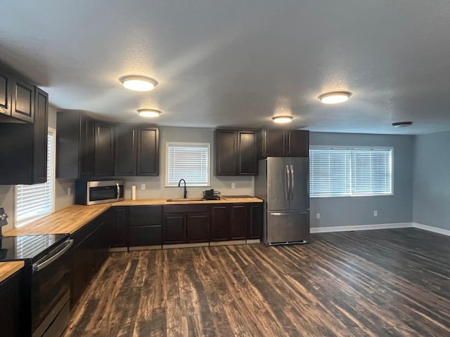 kitchen featuring a textured ceiling, dark hardwood / wood-style flooring, stainless steel appliances, and sink