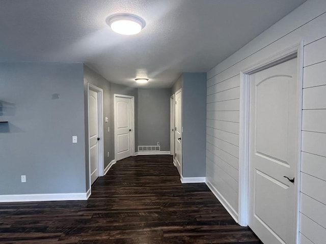 hall featuring dark hardwood / wood-style flooring and a textured ceiling