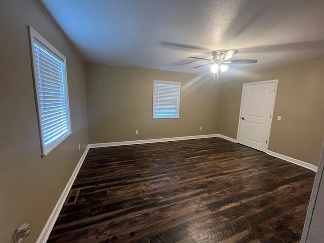 spare room featuring ceiling fan, dark wood-type flooring, and a textured ceiling