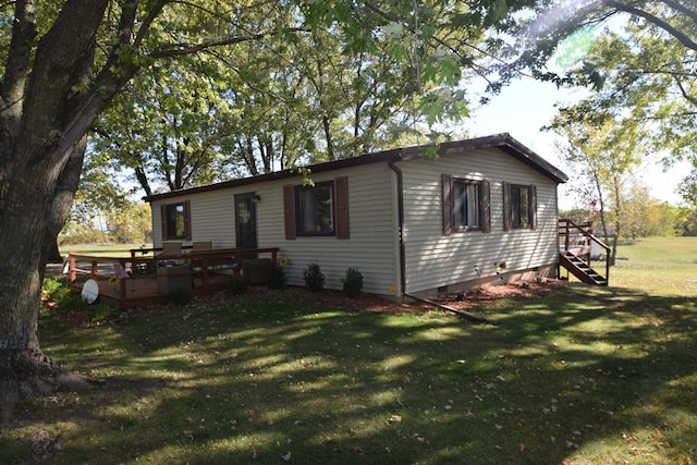 view of front facade featuring a wooden deck and a front lawn