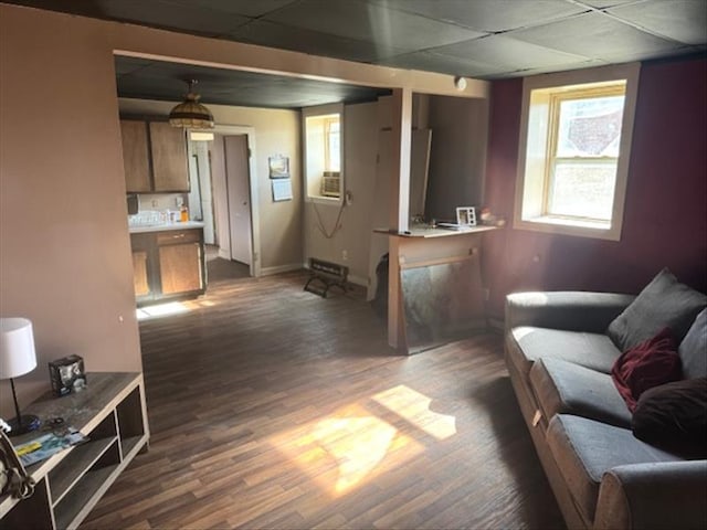 living room with a paneled ceiling and dark wood-type flooring