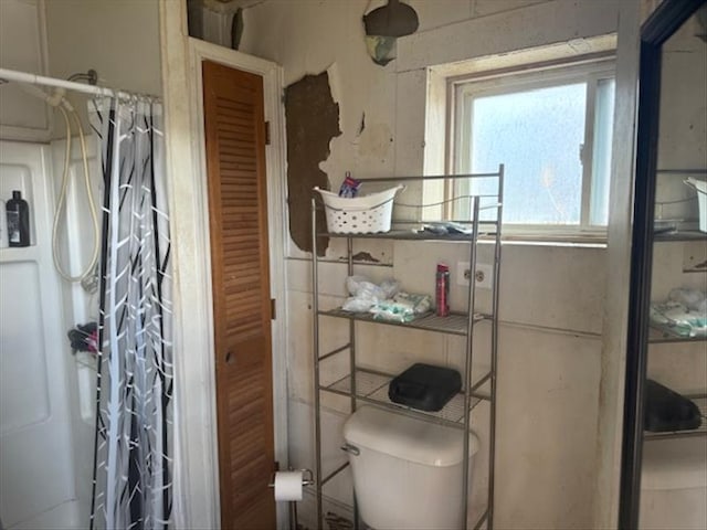 bathroom featuring a shower with curtain and toilet