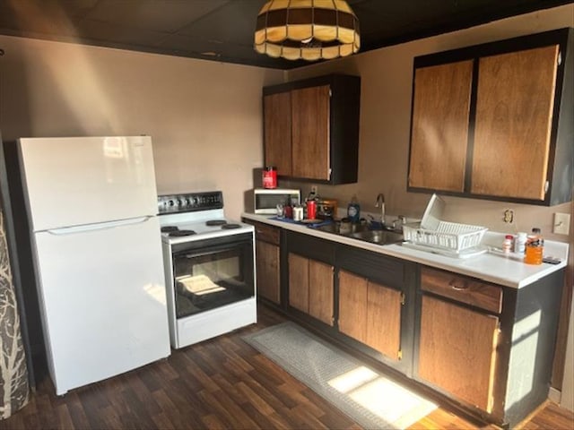 kitchen featuring sink, dark hardwood / wood-style floors, and white appliances