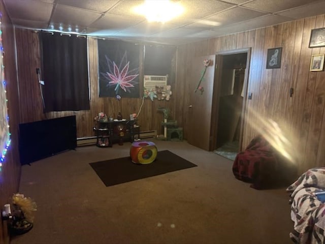 interior space with carpet flooring, wooden walls, and a baseboard radiator