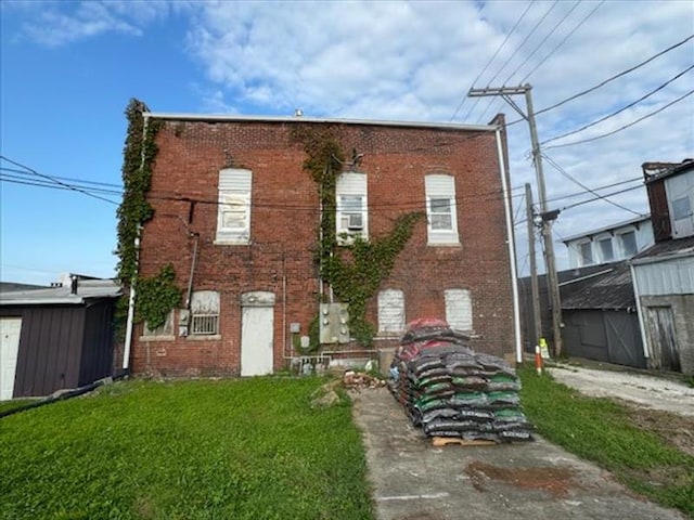 view of front of property with a storage unit and a front yard