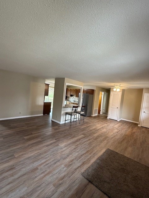 unfurnished living room featuring dark hardwood / wood-style floors and a textured ceiling